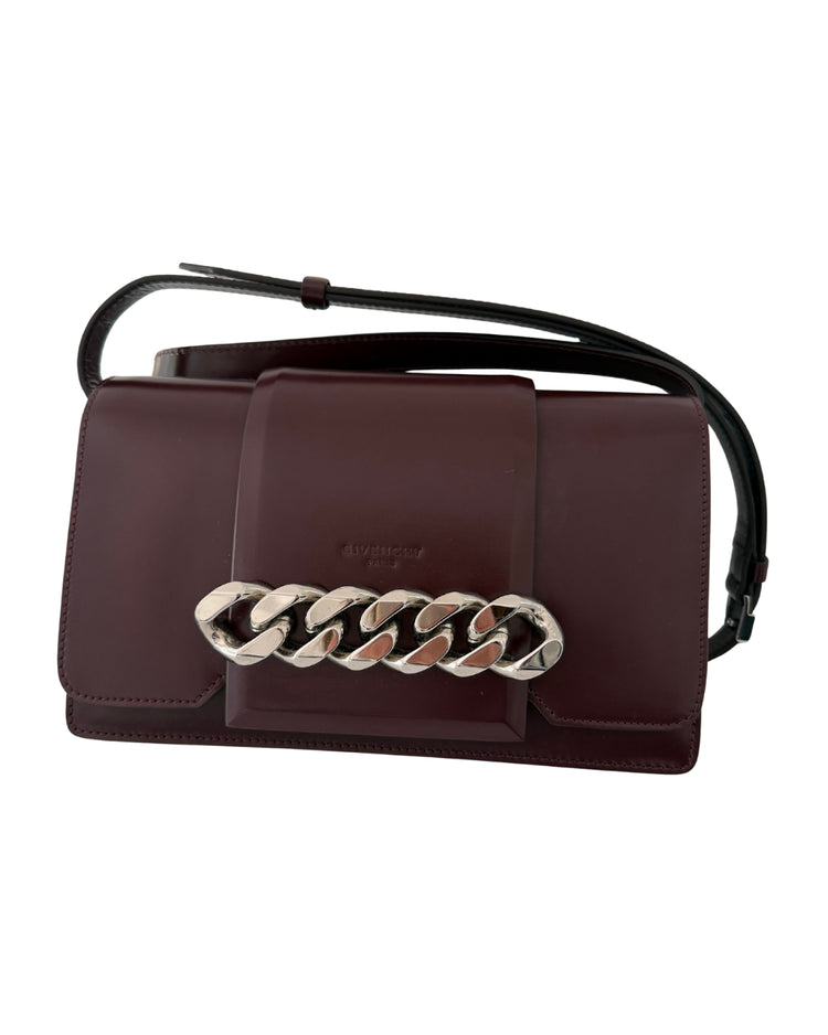 Brown handbag with a chain detail on a white background