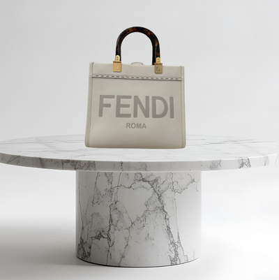 Fendi handbag on a marble pedestal against a white background